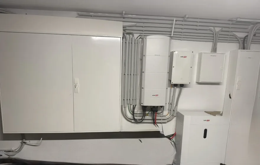 Zähleranlage mit Wechselrichter, Stromspeicher und sauber verlegten Leitungen an einer Wand